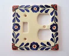 a decorative light switch cover with blue and red flowers