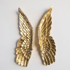 two gold angel wings on a white background