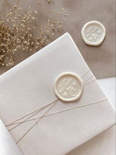 two wax seals on top of a white envelope