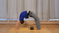 a man is doing yoga on a mat in front of a window