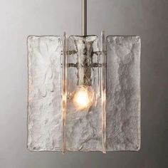 a light that is hanging from a ceiling fixture with glass blocks on the bottom and sides