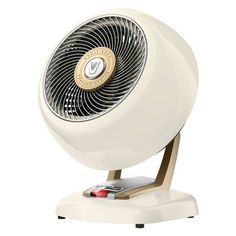 a white fan sitting on top of a wooden stand