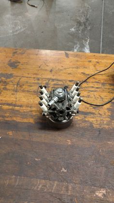 a metal object sitting on top of a wooden table next to a computer mouse and keyboard