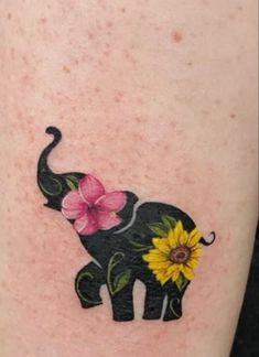 an elephant with flowers on it's back leg is seen in this tattoo design