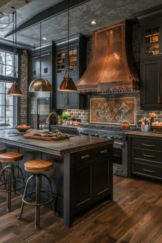 a kitchen with black cabinets and wooden floors