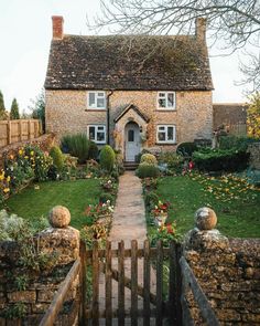 a stone house with a wooden gate in the front yard