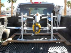 the back end of a pickup truck with an airplane on it's flatbed