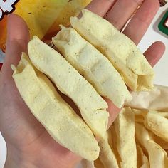 a person holding some kind of food in their hand with chips on the other side