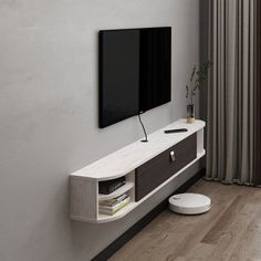 a flat screen tv mounted to the side of a wall next to a wooden floor