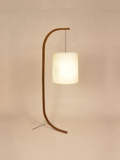 a lamp that is sitting on top of a wooden stand with a white light in front of it