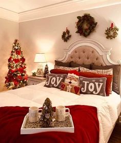 a christmas themed bedroom decorated in red and white with coffee mugs on the bed