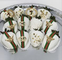 chocolate covered strawberries with gold decorations on them in a silver platter, ready to be eaten