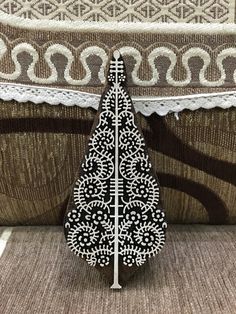 a black and white brooch sitting on top of a table next to a curtain