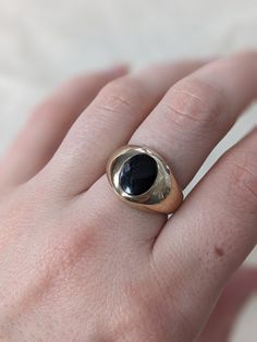 This chunky signet ring is so fun and bold, but still casual enough for every day wear. It is hefty and domed with an oval black onyx inlay. Crafted in 10k yellow gold this piece weighs 7.59 grams. It is currently a US size 7.25 but could be sized slightly up or down by your local jeweler. It is in great vintage condition with minimal light wear to the surface of the metal but no dents or dings. Everyday Black Signet Ring With Polished Finish, Modern Black Oval Signet Ring, Classic Oval Black Enamel Signet Ring, Black Vintage Jewelry For Everyday, Vintage Black Jewelry For Everyday, Black Vintage Everyday Jewelry, Vintage Oval Signet Ring For Everyday, Everyday Vintage Oval Signet Ring, Vintage Black Signet Ring With Polished Finish