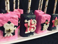 pink and black birthday cake with candles on it's sides for the number thirteen