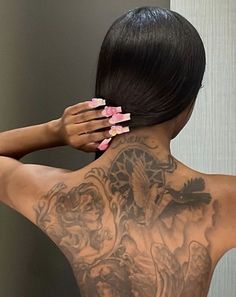 the back of a woman's body with tattoos on her upper and lower back