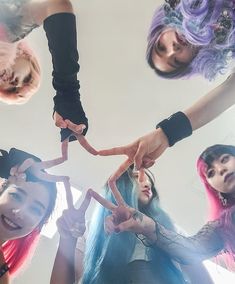 a group of young women standing next to each other with their hands in the air