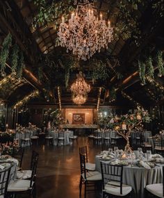 an indoor wedding venue with chandeliers and tables