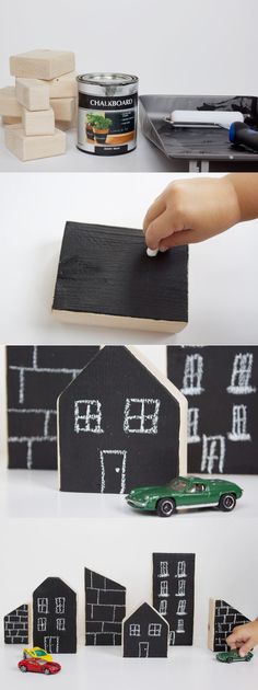 a hand is holding a piece of black paper with white writing on it and some wooden blocks