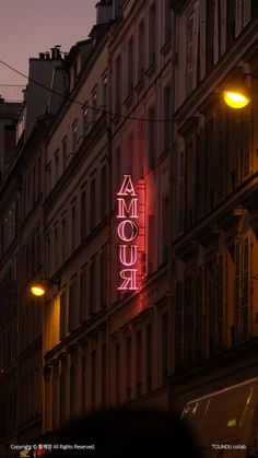 a neon sign is lit up on the side of a building in paris, france