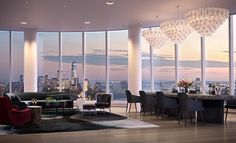 a living room filled with furniture and large windows overlooking the city at sunset or dawn