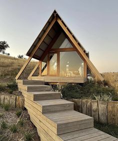 a wooden cabin with stairs leading up to it