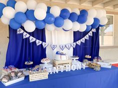 a blue and white dessert table with balloons