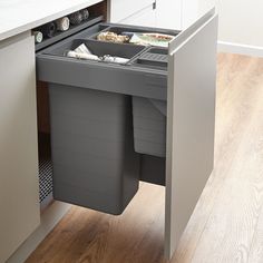 an open trash can in the middle of a kitchen