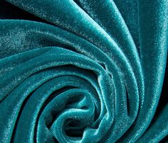 a close up shot of the fabric in teal green color, it is very soft and shiny