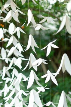 some white paper birds hanging from a tree