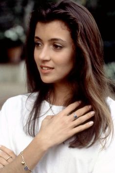 a close up of a person with a ring on her finger and wearing a white shirt