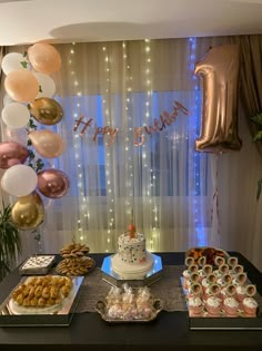 a table topped with lots of desserts and balloons