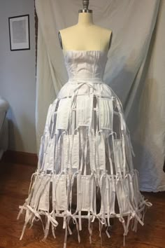 a dress made out of white fabric on a mannequin