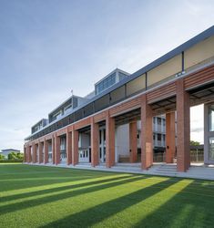 the building is made out of red bricks and has grass on the ground in front of it