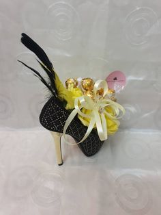 a shoe decorated with candy and feathers on a white background for someone's special occasion