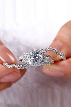 a person holding a diamond ring in their hand