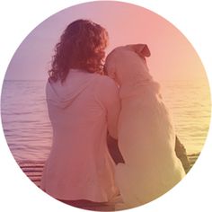 two women sitting on a dock looking out at the water with their backs to each other