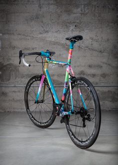 a colorful bicycle parked in front of a concrete wall