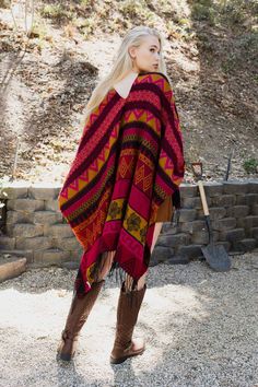 Looking for a stylish and unique poncho that will make you stand out from the rest? Look no further than the Aztec Inspired Go West Ruana! This one-of-a-kind ruana is perfect for those chilly days or nights when you want to add a little extra warmth and style. The bold and eye-catching Aztec print is sure to turn heads, while the warm and cozy fabric will keep you comfortable all day long. Whether you're headed to the office or out on the town, this ruana is a must-have fashion statement piece t Red Poncho For Festival In Fall, Pink Shawl For Fall, Bohemian Multicolor Wrap For Fall, Bohemian Multicolor Wraps For Fall, One Size Cape For Fall Festival, Red Poncho For Beach In Fall, Bohemian Poncho With Scarf For Festivals, Multicolor Bohemian Poncho With Scarf, Bohemian Red Cape For Festivals