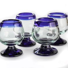 four glass goblets sitting on top of each other in front of a white background