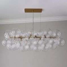 a chandelier hanging from the ceiling with clear glass balls in front of it