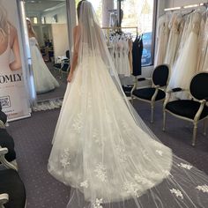 a woman in a wedding dress looking at herself in the mirror while she is getting ready to walk down the aisle