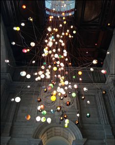 a very large chandelier hanging from the ceiling in a building with lots of lights