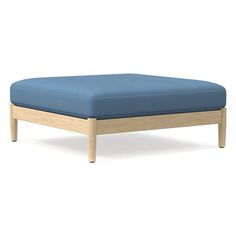 a blue ottoman sitting on top of a wooden frame