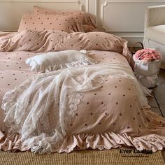 an unmade bed with pink sheets and pillows