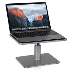 an open laptop computer sitting on top of a metal stand in front of a white background