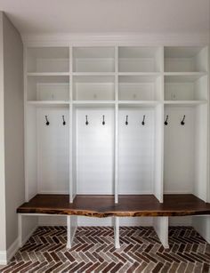 an empty room with white shelves and wooden benches