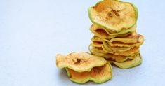 a pile of sliced apples sitting on top of a white table next to each other