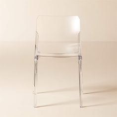 a clear plastic chair sitting on top of a white floor next to a beige wall