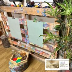 a plant in a pot next to a wooden board with memos on it and other items